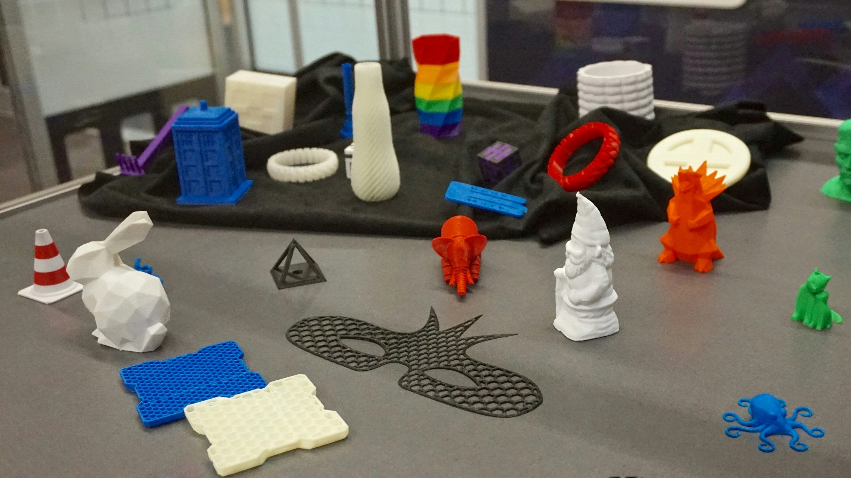Workbench covered in colorful 3D printed toys and figures